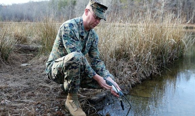 A man using a water filter in a pond