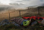woman in a sleeping bag watching the sunset