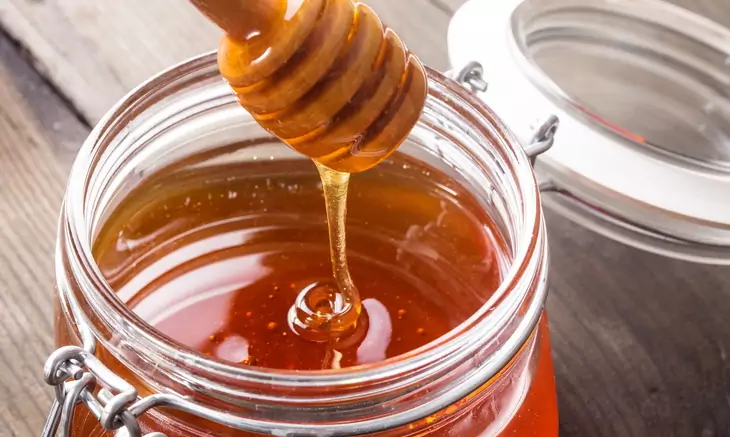 Honey drip in jar on the table