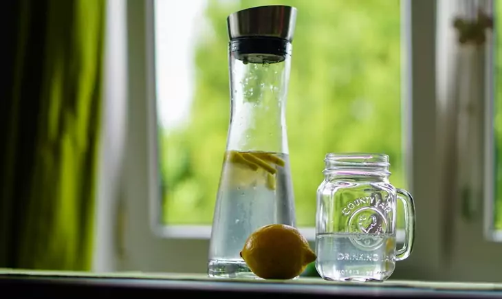 Shallow Focus Photography of Yellow Lemon Near Glass Mason Jar and Glass Decanter