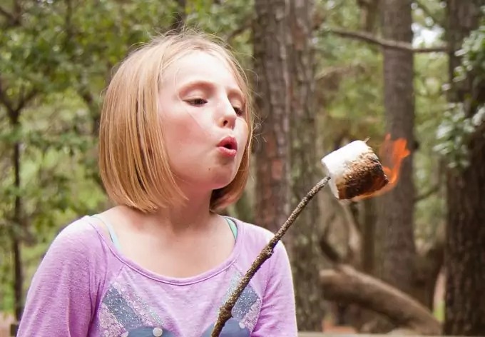 little girl cooking campfire dessert