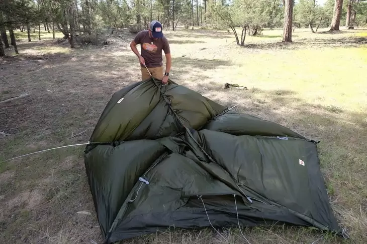 man drying his tent of condensation or moisture