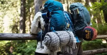 Backpackers sitting on a bridge in the forest