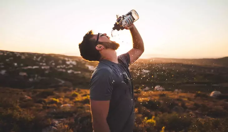 Man Pouring Water Bottle on His Mouth