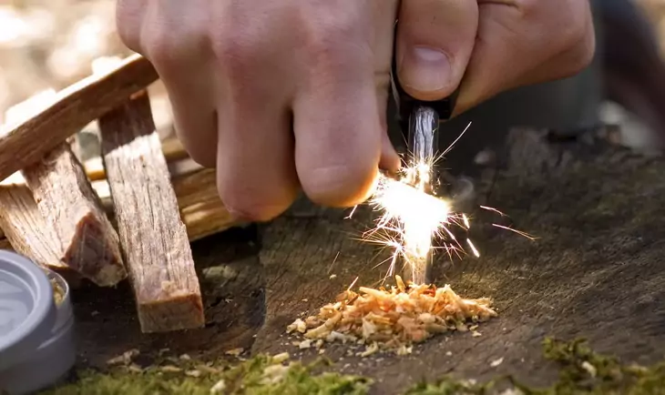 Man trying to start a fire in the forest