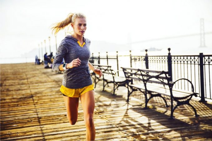 Girl running with a heart rate monitor