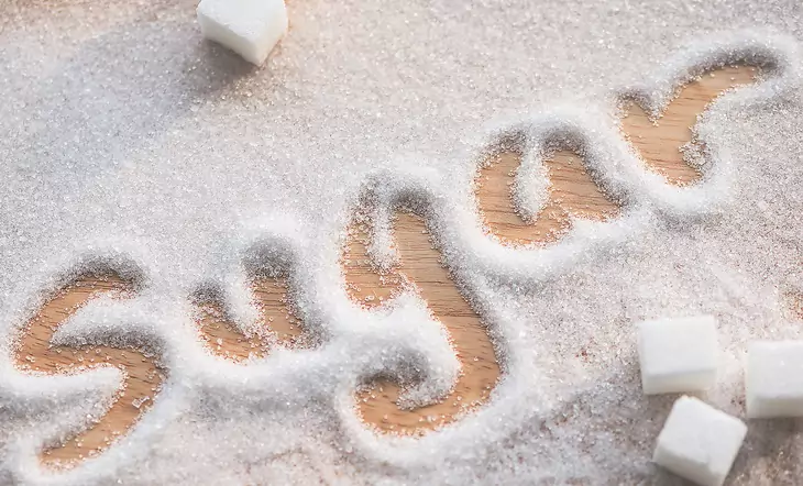 Inscription sugar made into pile of white granulated sugar