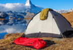 Two sleeping bags, a tent and the mountains in the background