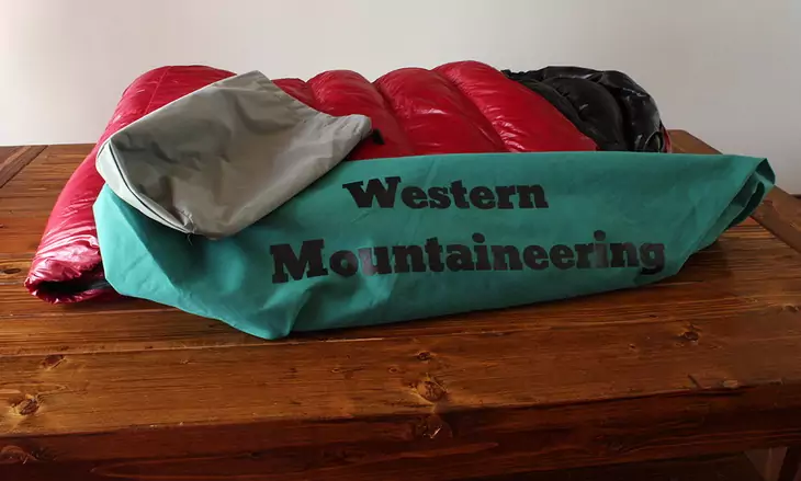 Western Mountaineering Sycamore sleeping bag on a brown wooden table