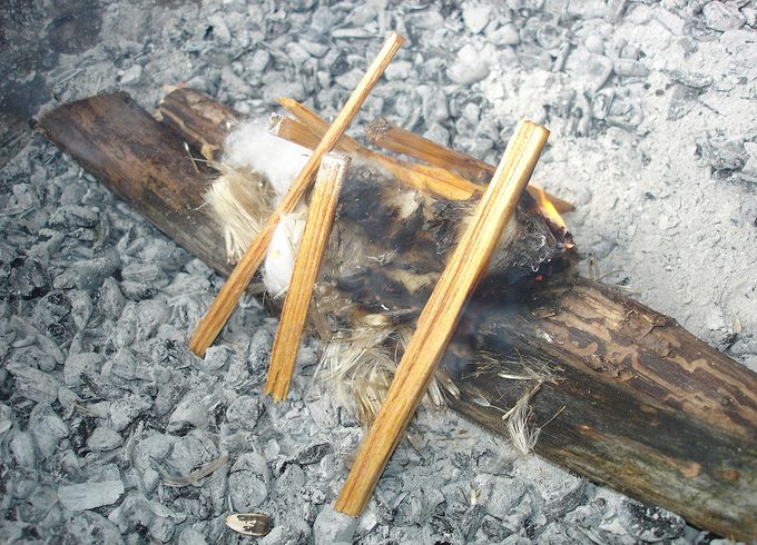 A fire being started by a bow drill