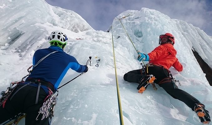 Alpinists climbing an iced rock