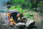 A man that has just started a fire outdoors