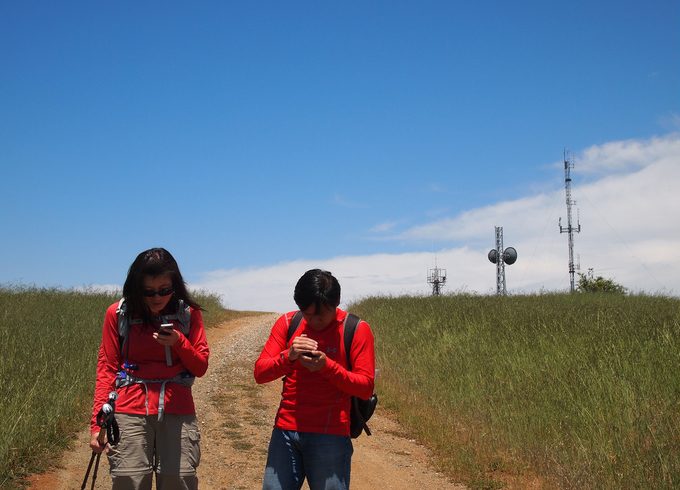 Hikers being lost and watching their mobile devices