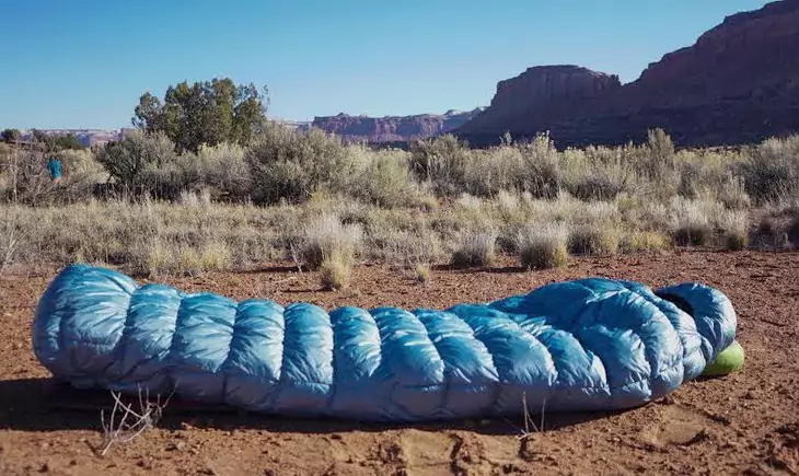 sleeping bag on the ground and grand canyon in the background