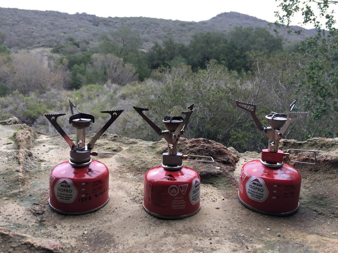 Image showing three A MSR PocketRocket Stove outside on the ground.