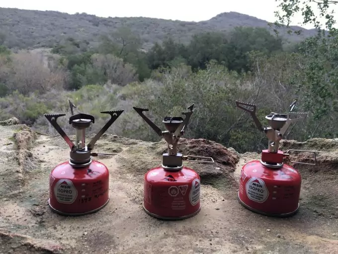 Image showing three A MSR PocketRocket Stove outside on the ground