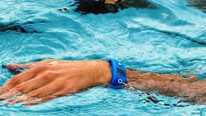 A man swimming in the pool while is wearing a waterproof-fitness-tracker