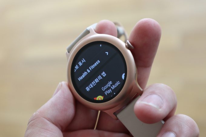 A person holding a smartwatch in their hands 