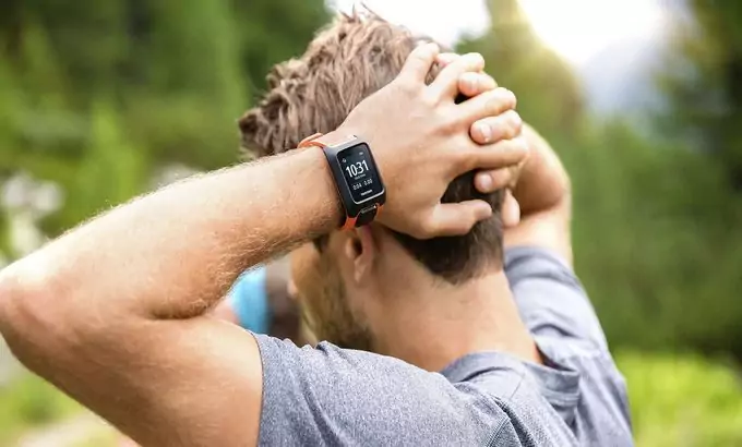 A runner with his hands on the head wearing a GPS fitness tracker