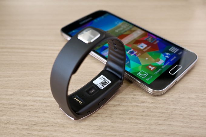 Samusung galaxy S5 and smartwatch on a wooden table