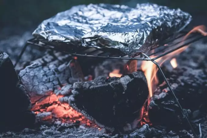 Food being cooked under aluminum foil