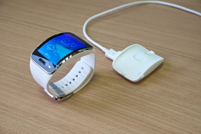 Image showing a white smartwatch and a charger on a table