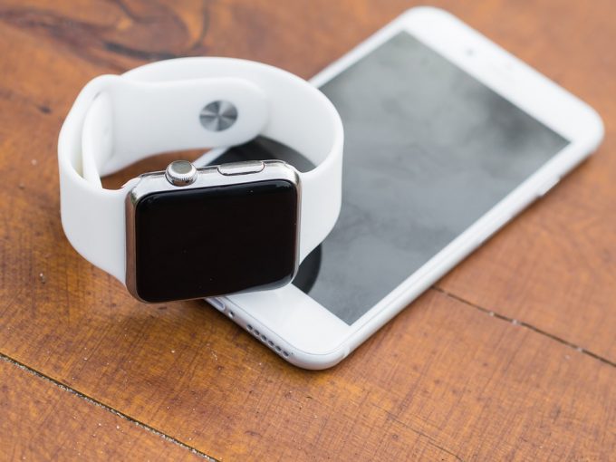 Image showing a white fitness watch and an iphone on the table