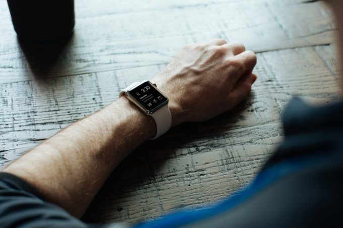 A man wearing fitness watch with arm on the table