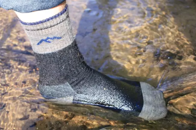 stepping into pond with waterproof socks