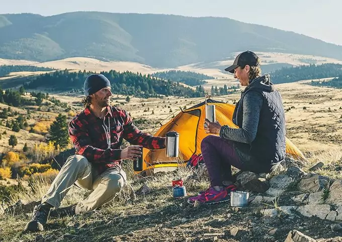 couple drinking hot coffee on camp