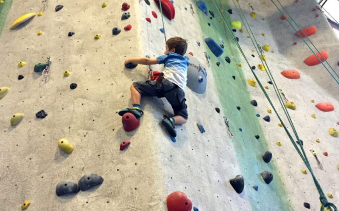 kid learning to rock climb