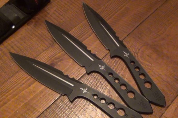 three throwing knives on wooden table